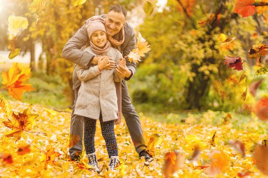 happy family father and child girl daughter playing and laughing in autumn park . High quality photo
