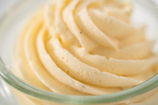 Swirl of eggnog buttercream frosting in a small glass bowl.