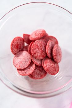 Melting red chocolate chips in a candy melting pot to make chocolate lips and heart shaped chocolates for Valentine's Day.