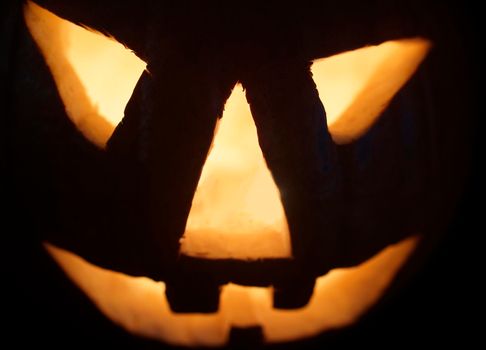 Glowing nightmare face of jack-o-lantern in the darkness. Halloween festival