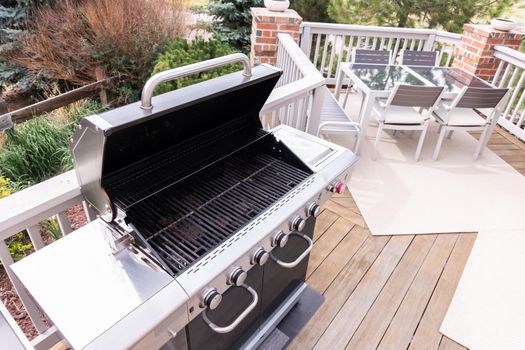 Outdoor six-burner gas grill on the back patio of a luxury single-family home.