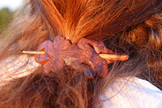 Red hair of a  woman with a gecko shaped wooden hair clip