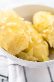 Mashed potatoes. Cooking whole peeled potatoes in a white bowl.