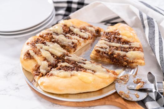 Freshly baked cinnamon dessert pizza with cream cheese drizzle.