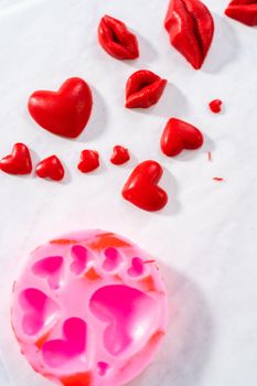 Dusting chocolate lips and heart-shaped chocolates with editable glitter for Valentine's Day.