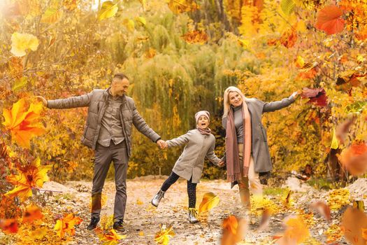 Family playing in autumn park having fun. High quality photo