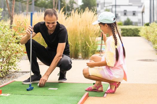 Closeup of player play mini golf with ball.