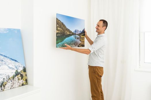 Modern Home Interior And Domestic Decor. a man is holding a photo canvas.