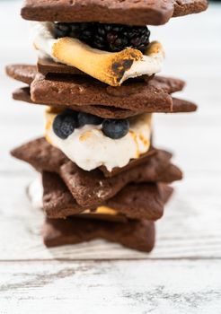 Making s'mores on a homemade star-shaped chocolate graham cracker with toasted marshmallow and fruits.