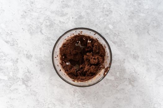 Flat lay. Mixing ingredients in a large glass mixing bowl with a kitchen mixer to bake chocolate cookies with peppermint chips.