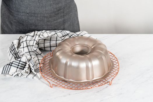 Cooling freshly baked red velvet bundt cake on a kitchen counter.