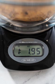 Pressure Cooker Baked Potatoes. Measuring raw potatoes in a glass mixing bowl on the kitchen scale.