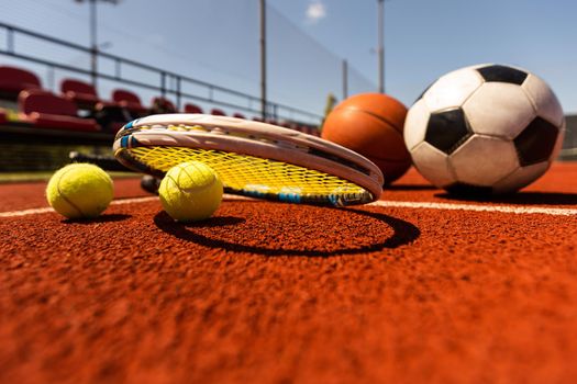 Set of sport equipment, rackets and tennis balls soccer and basketball balls.