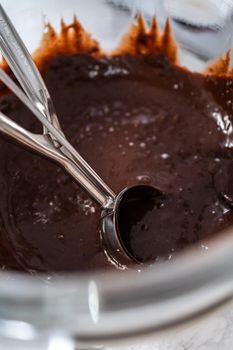 Baking chocolate cupcakes. Scooping chocolate cupcake batter into a cupcake pan.