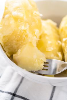 Mashed potatoes. Cooking whole peeled potatoes in a white bowl.