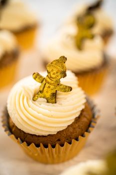 Freshly baked gingerbread cupcakes with eggnog buttercream frosting and topped with a gingerbread man.