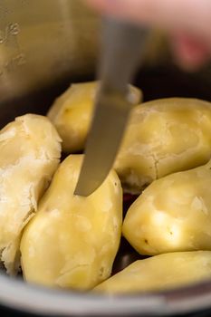 Mashed potatoes. Cooking whole peeled potatoes in a pressure cooker to make mashed potatoes.