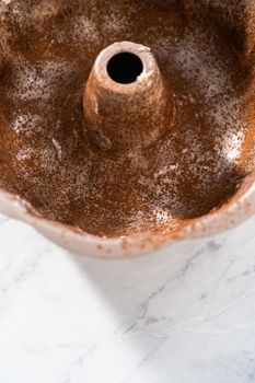 Greasing metal bundt cake pan to red velvet bundt cake with cream cheese glaze.