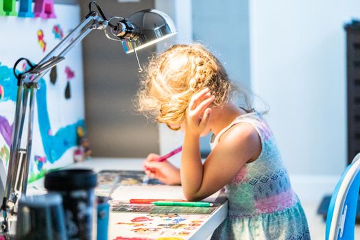 Little girl studying at home during the e-learning school.