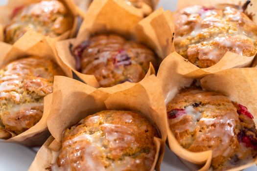 Freshly baked cranberry muffins in brown paper muffin cups.