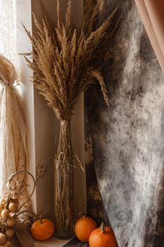 Autumn interior in a photo studio, with pumpkins and dry grass.