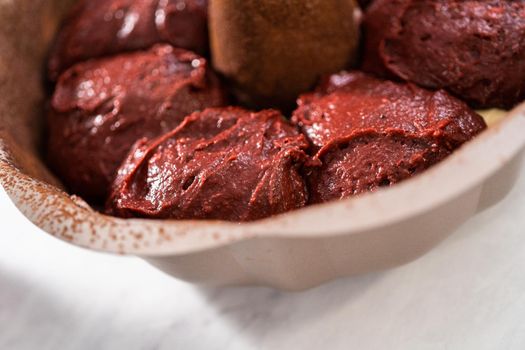 Filling metal bundt cake pan with cake butter to bake red velvet bundt cake with cream cheese glaze