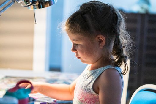 Little girl studying at home during the e-learning school.