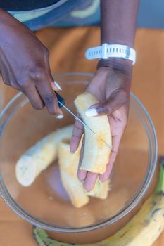 woman chef preparing african caribbean food with plantain plane tree fruit