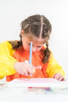 Little girl working on an art project with acrylic paint at homeschool.