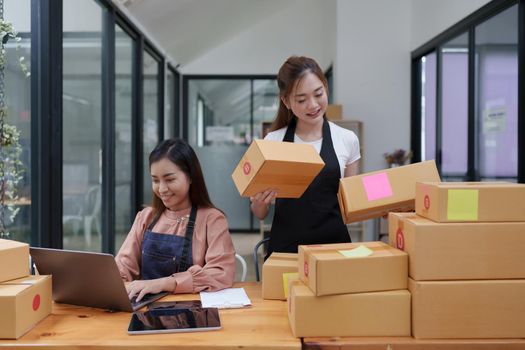 Two Asian SME business woman working at home office. online shopping concept.