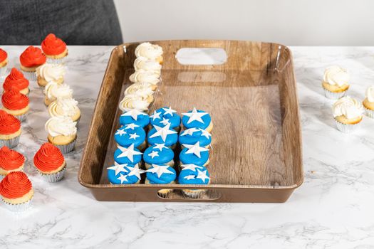 Arranging mini vanilla cupcakes in the shape of the American flag.