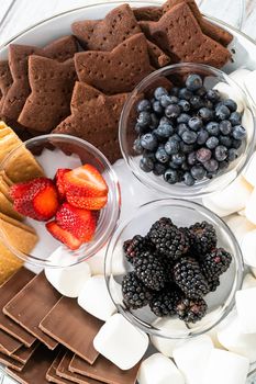 Arranging fruit s'mores charcuterie board on a white tray.