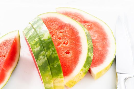 Slicing riped red watermelon to prepare chili lime watermelon pops.