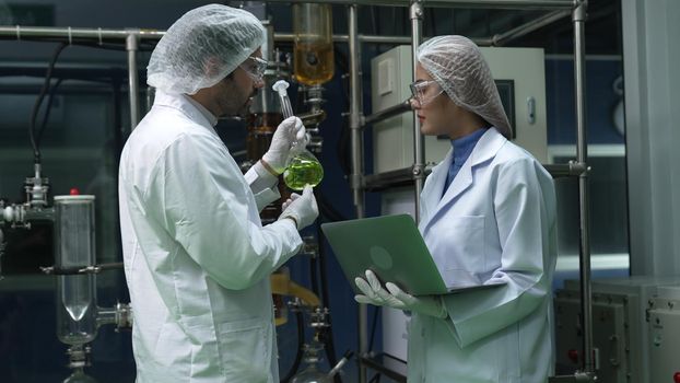 Two scientist in professional uniform working in laboratory for chemical and biomedical experiment