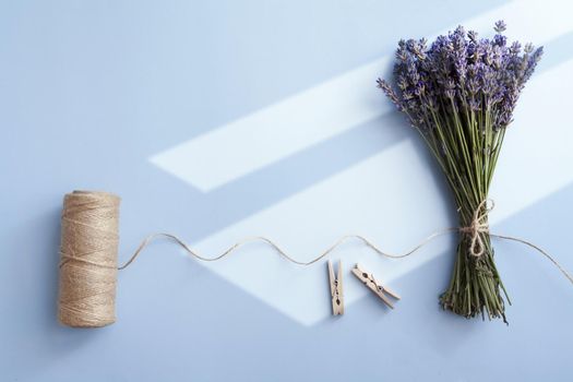 Lavender bunch and twine on a blue background with sun light top view. High quality photo