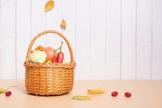 Autumn harvest basket with apples, zucchini and peppers on a wooden background. High quality photo