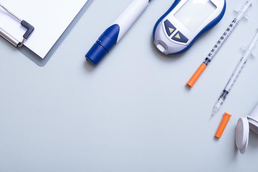 Glucometer and syringes with tablet on color background top view. Means for controlling blood sugar flat lay.