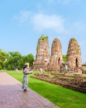 Ayutthaya, Thailand at Wat Mahathat, women with a hat and tourist maps visiting Ayyuthaya Thailand. Tourist with map in Thailand