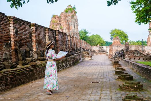 Ayutthaya, Thailand at Wat Mahathat, women with a hat and tourist maps visiting Ayyuthaya Thailand. Tourist with map in Thailand