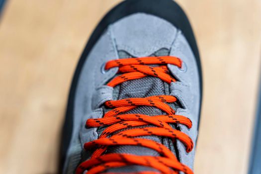 shoe lace close up look. bright orange shoelaces. New Modern leather Mountain Boots with lacing close-up