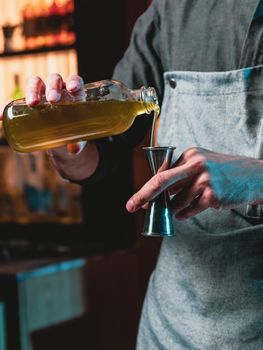 Bartender at nightclub preparing cocktails with bar equipment