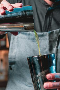 Bartender at nightclub preparing cocktails with bar equipment