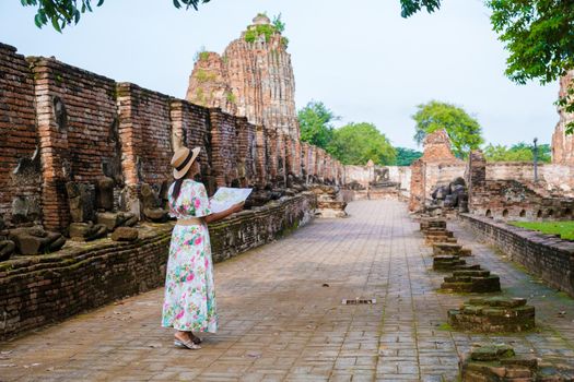 Ayutthaya, Thailand at Wat Mahathat, women with a hat and tourist maps visiting Ayyuthaya Thailand. Tourist with map in Thailand