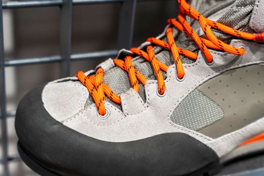 shoe lace close up look. bright orange shoelaces. New Modern leather Mountain Boots with lacing close-up