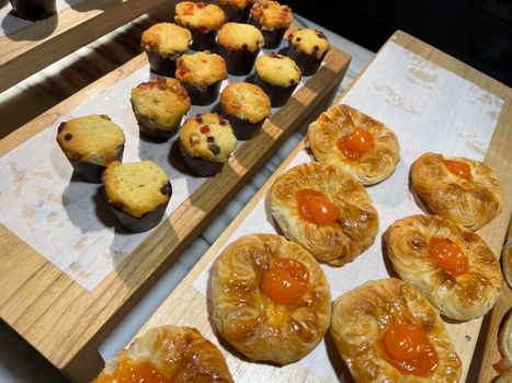 Lines of fresh baked sweet puff pastry stuffed with apricot and peach jelly, super delicious warm fresh buttery sweet puff pastry stuffed with apricot and peach, French and American baked pastries are enjoyed world wide on bakery shop, tasty multiple sweet puff pastry stuffed with apricot and peach