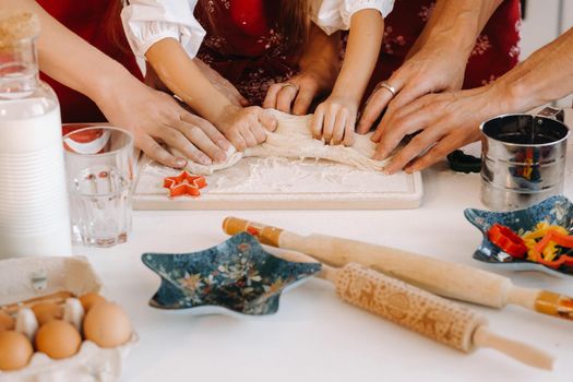 Close-up of hands cooking dough on the Christmas kitchen table.