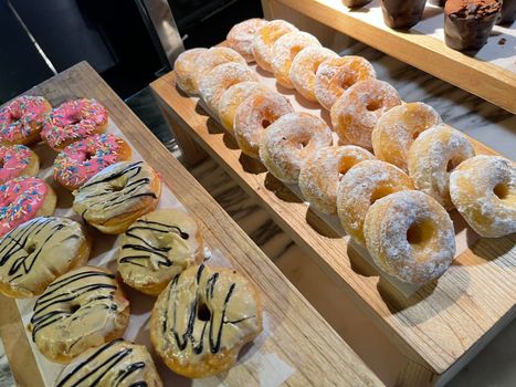Lines of fresh delicious donuts on bakery shop, tasty multiple donuts, Selective focus donuts with various topping