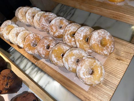 Lines of fresh delicious donuts on bakery shop, tasty multiple donuts, Selective focus donuts with various topping