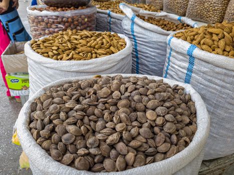 Oriental Bazaar. Almond peeled and unpeeled, nuts sales in market. Dry food, variety almonds in store. Concept of healthy eating, raw product, bazaar, diet, almond theme.