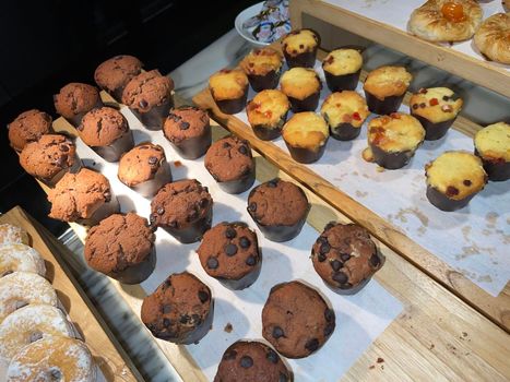 Lines of delicious chocolate and vanilla muffins Freshly baked homemade chocolate chip muffins Out of the oven muffins in muffin cups